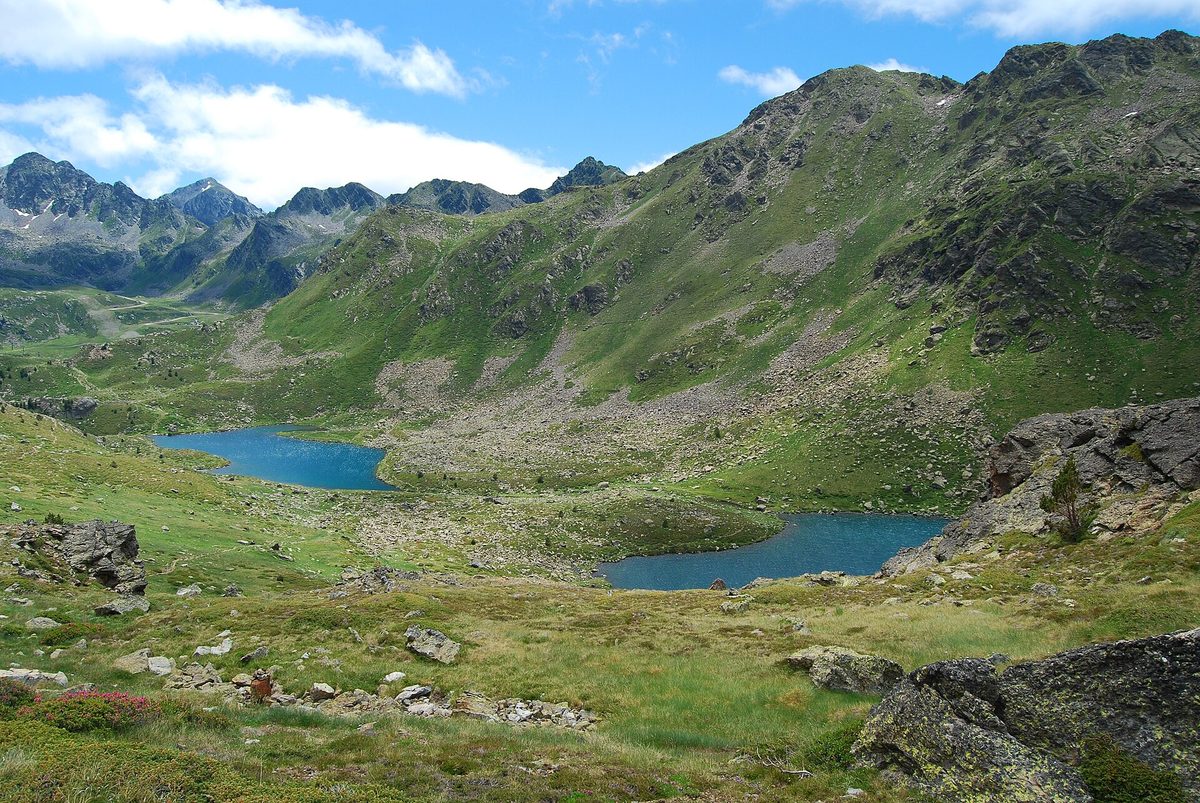 Turquoise Tristaina mountain lakes in Ordino, Andorra, ringed by green summer slopes
