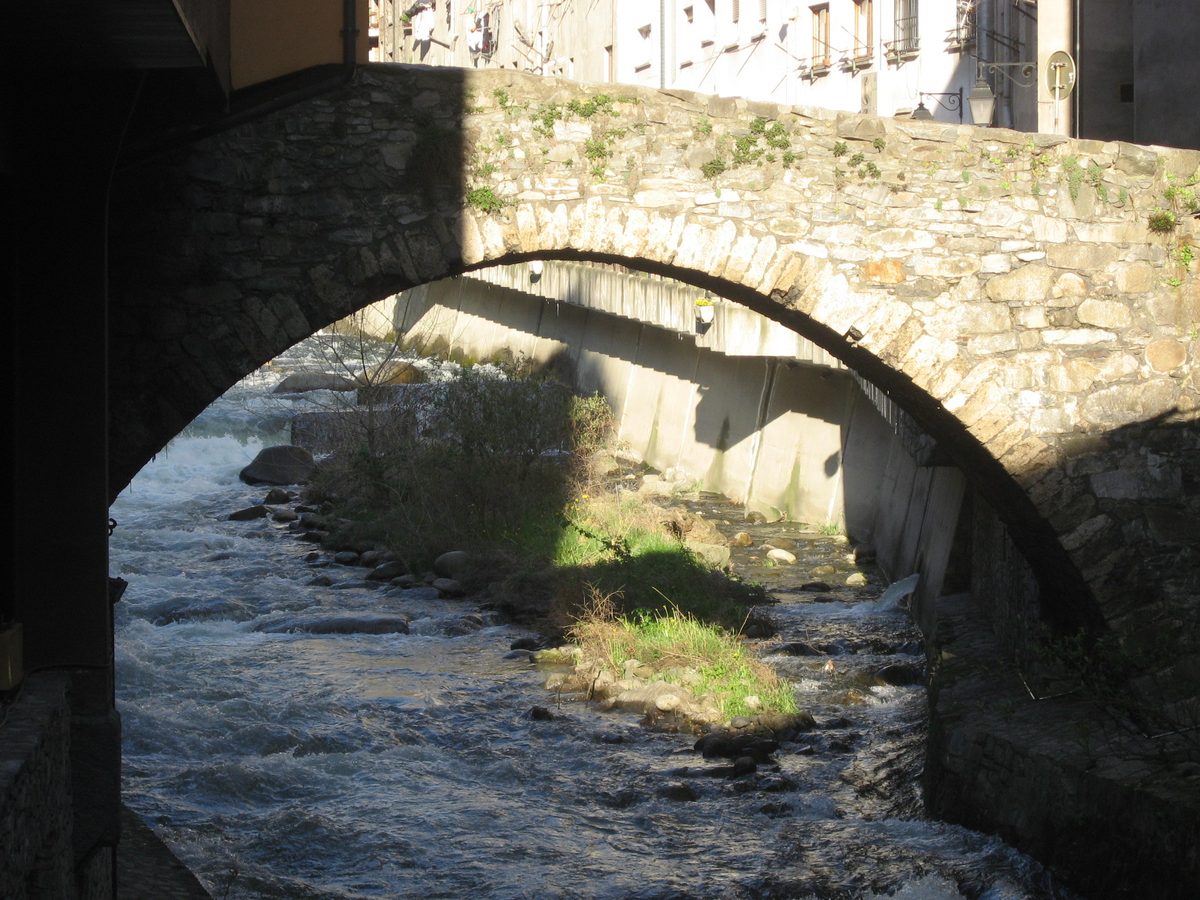 A historic stone arch bridge over the river in Escaldes-Engordany, Andorra
