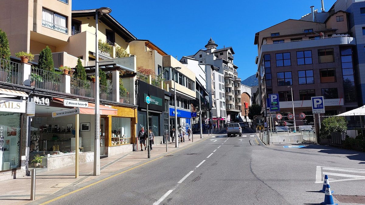 Shop windows and parking signs on Avinguda Meritxell in Andorra la Vella, the street where most visitors judge whether Andorra is cheap for shopping