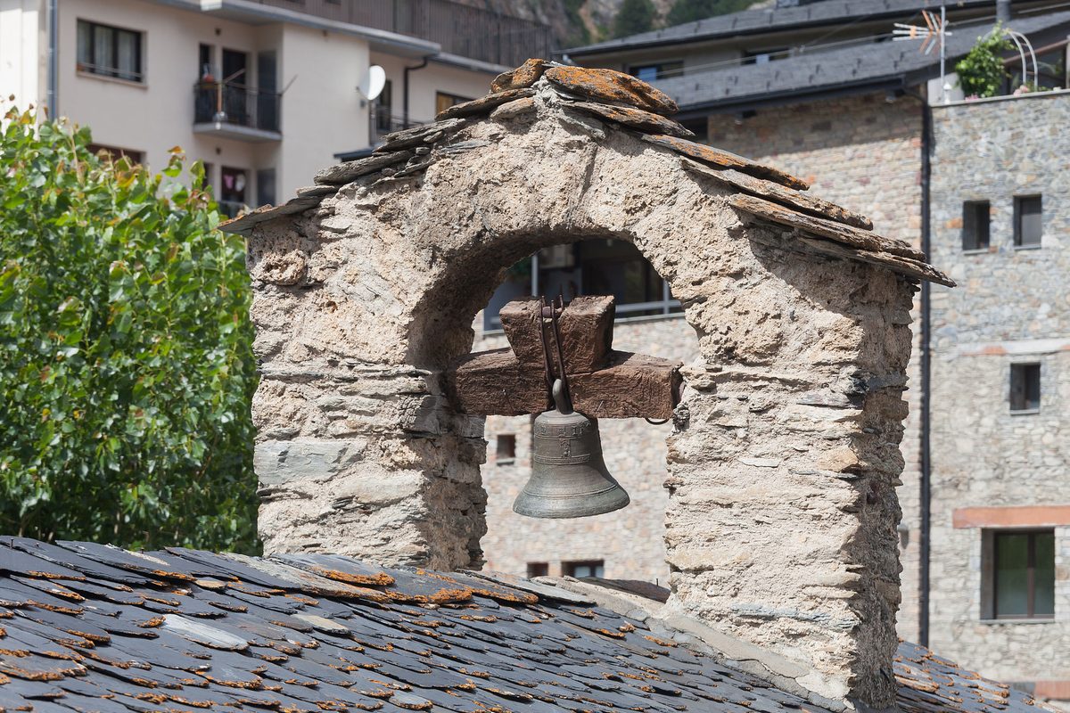 A stone bell-cot on a slate roof in an Andorran village