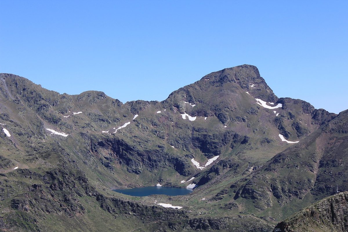 Distant view of Estany de Mes Amunt, the highest Tristaina lake, in its cirque below the rocky Pic de Tristaina